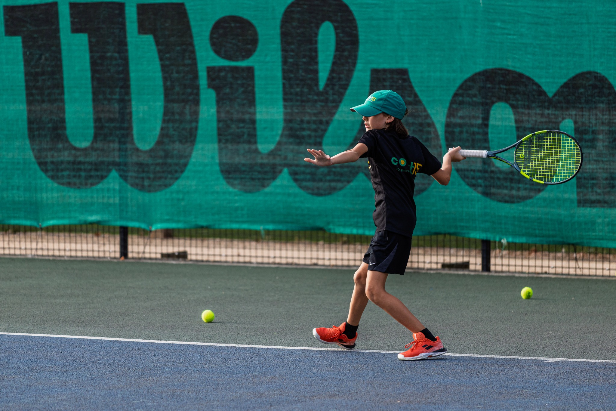 Junior tennis player preparing a forehand with a tennis racket on an outdoor court